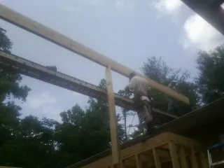 Carpenter setting a ridge beam over a new addition frame — Ice Dam Removal by Roofing Brothers in Sumava Resorts