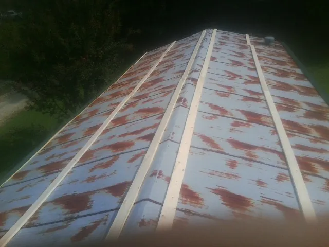 Rusted metal roof panels with new wood purlins before replacement — Storm Damage Roof Repair in Sumava Resorts by Roofing Brothers