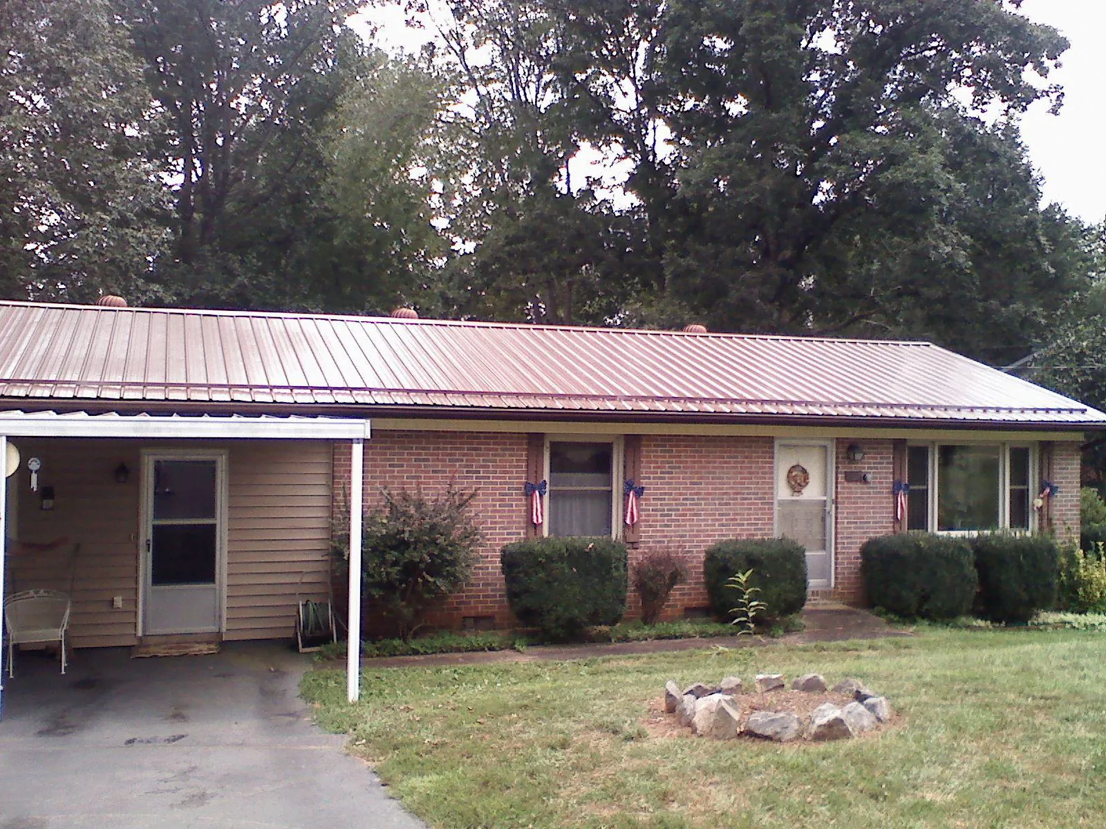 Bronze metal roof and carport on a brick ranch home — Roof Repair work by our crew in Sumava Resorts